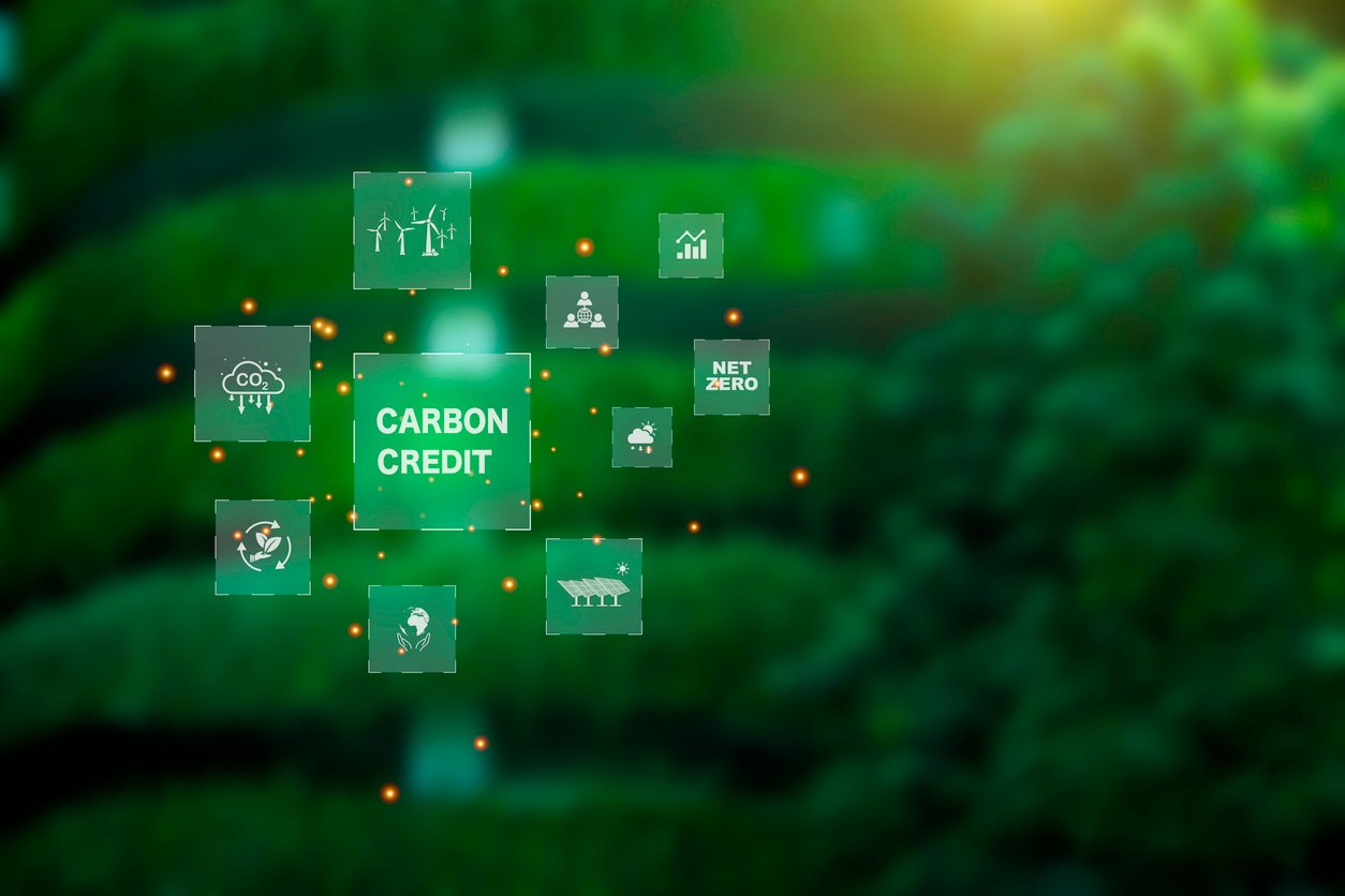 Carbon credit market concept. carbon credit icon on Green building covered with trees. Net zero in 2050. Green energy icon around it. Carbon Neutral in industry Net zero emission eco energy.